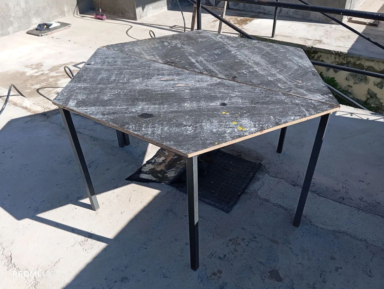 Mesa com design hexagonal e estrutura metálica 