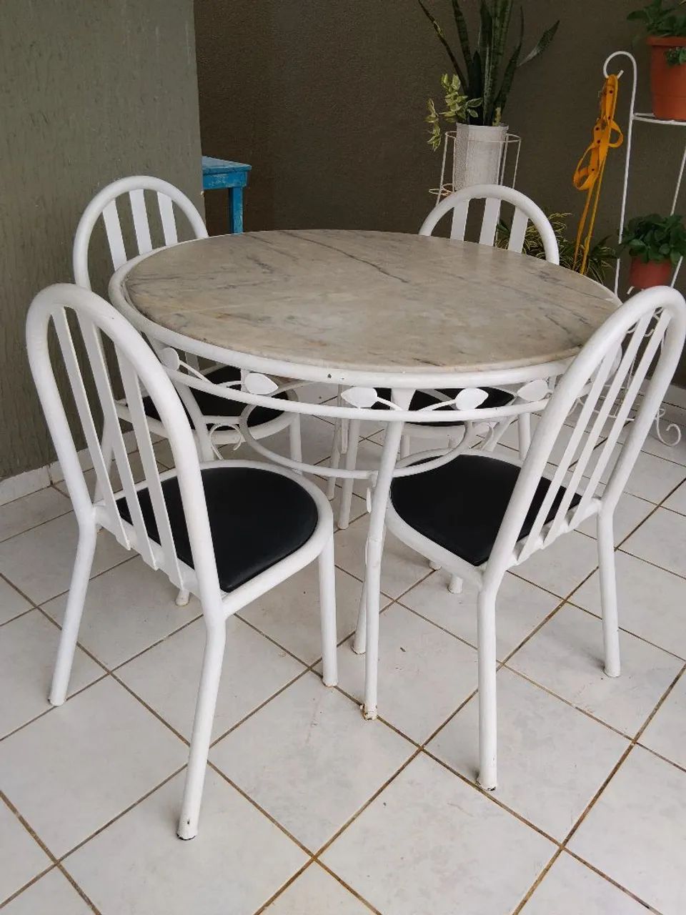 Mesa de mármore com quatro cadeiras de ferro turbular