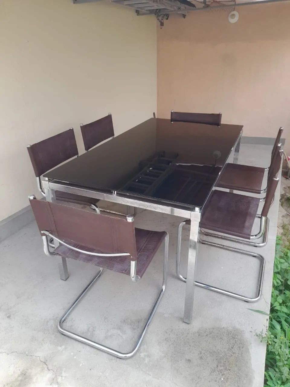 Mesa aço inox com tampo de vidro e cadeiras em couro