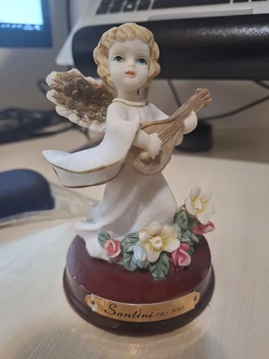 Estátua em resina de anjo tocando violão.