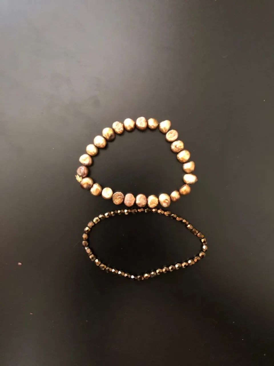 Duas pulseiras douradas, duas texturas. Rústica e brilhante no mesmo pulso.