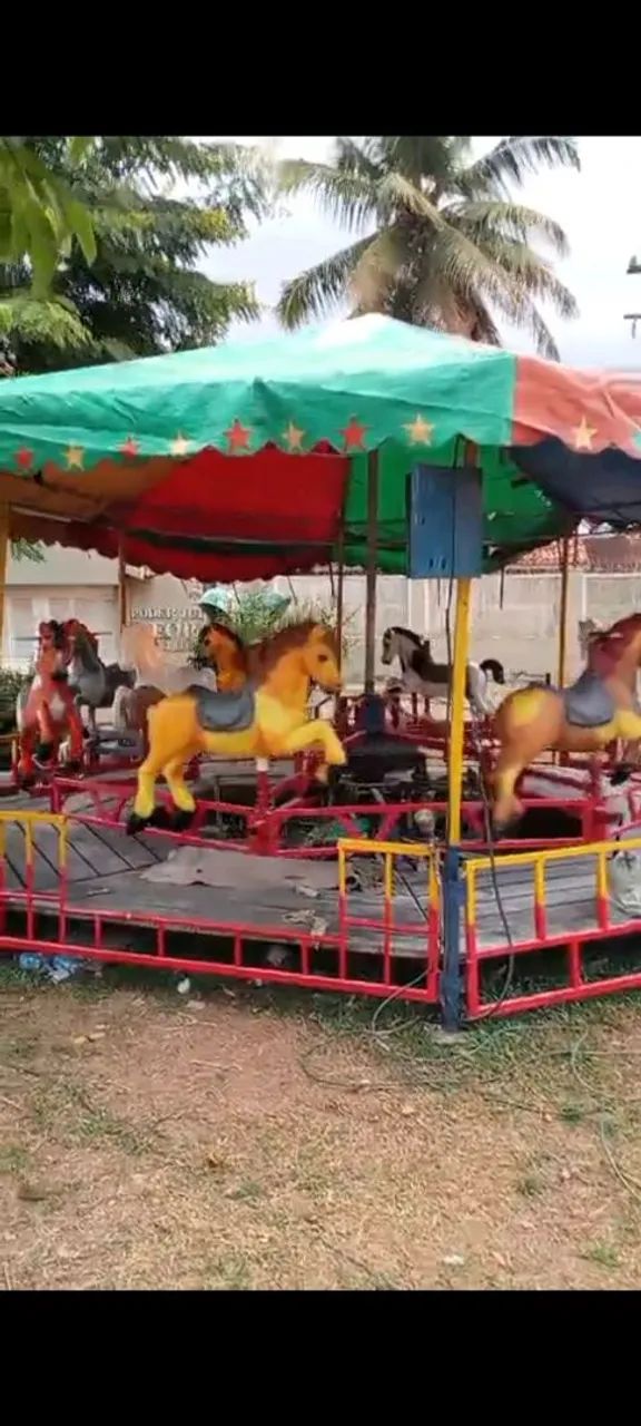 Carrocel de cavalinho brincando de Park de Diversões 