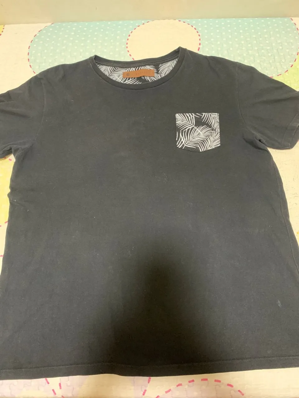 Camiseta preta com detalhe na gola e bolso