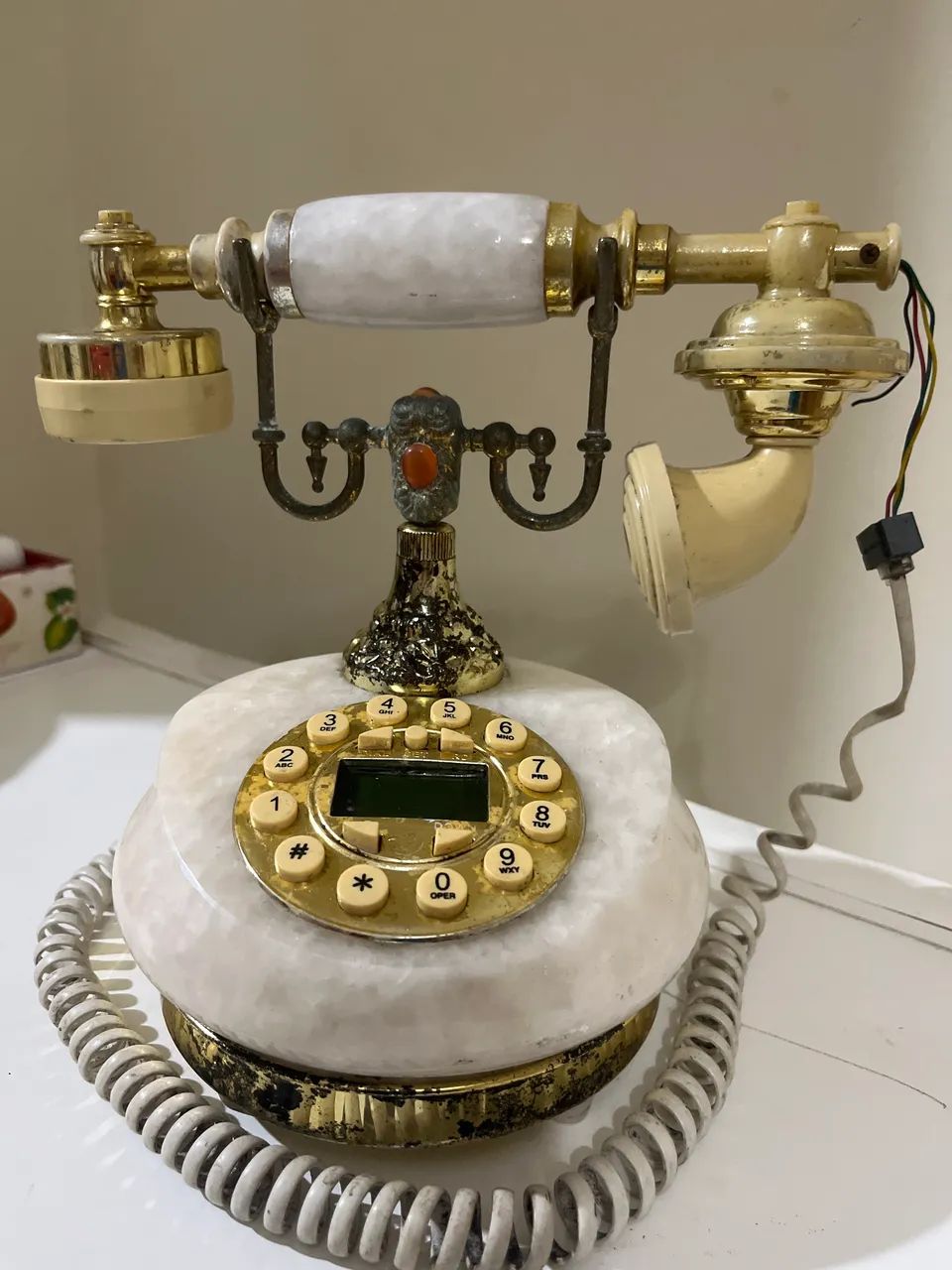telefone retrô de estilo europeu com detalhes em mármore sintético e dourado. 
