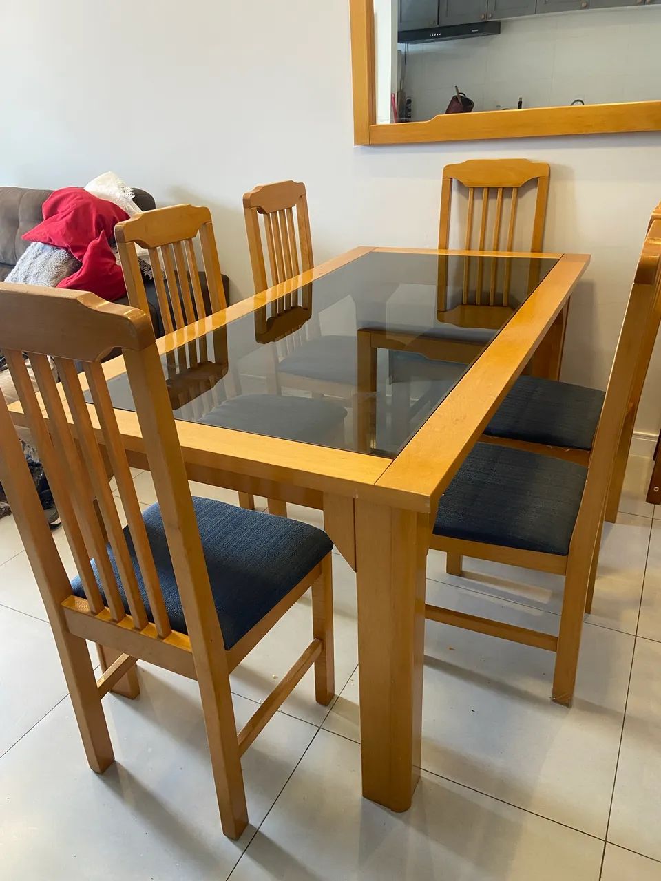 mesa de madeira com 6 cadeiras e espelho.