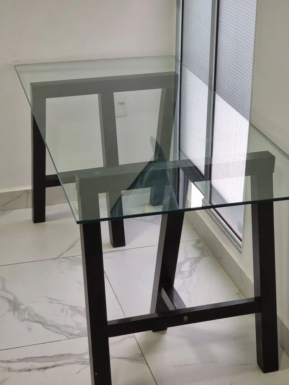 Mesa de jantar de vidro com cadeiras estofadas