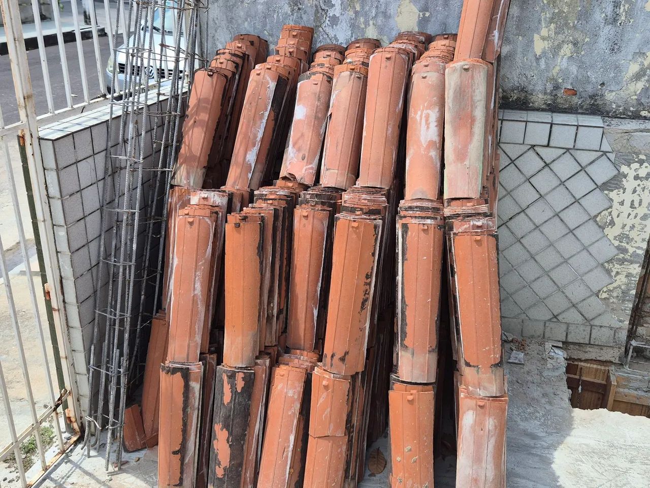 Janelas, telhas, grades e portão de ferro.