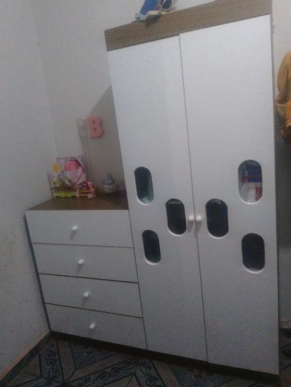 Quarto de bebê guarda-roupa, cômoda e cama berço sem colchão.