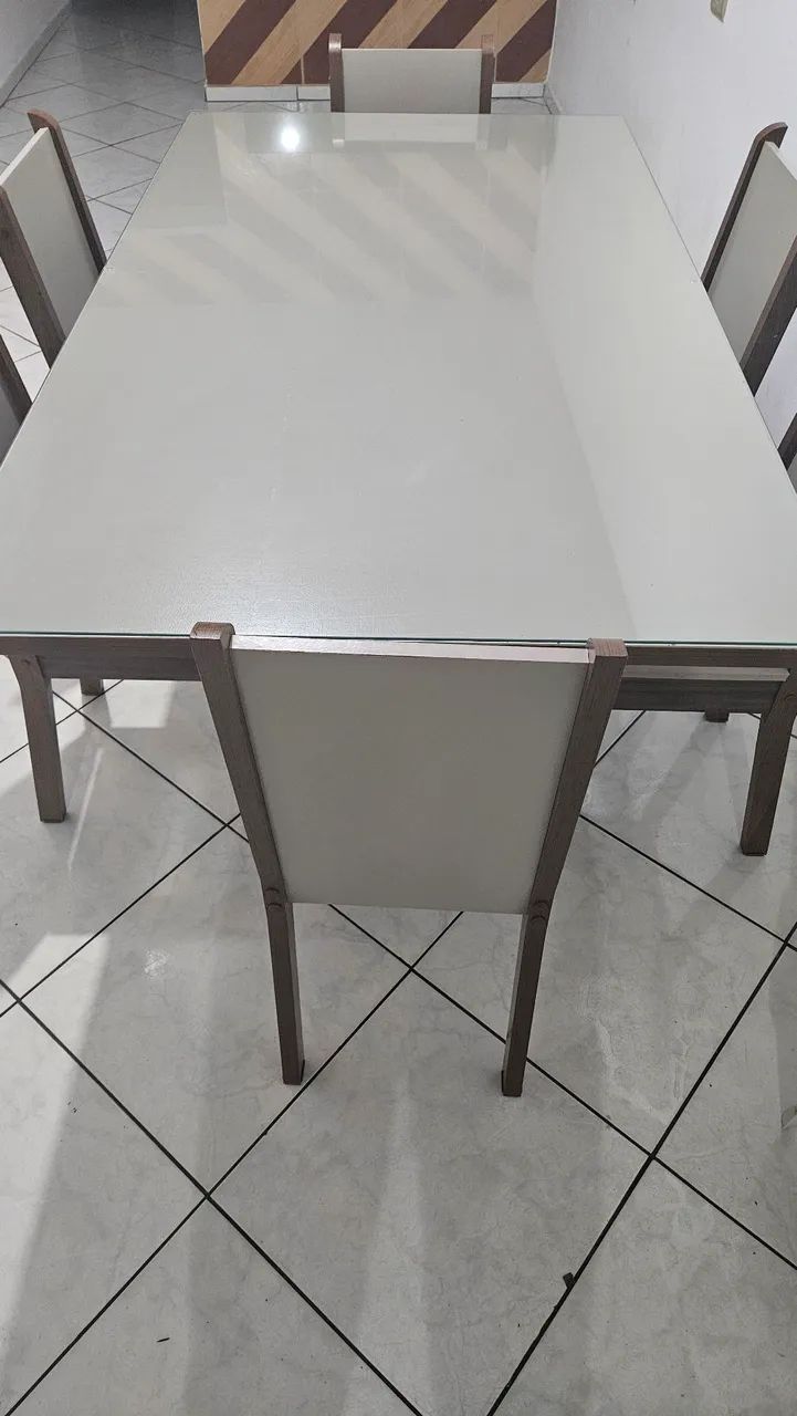 Mesa com tampo de vidro e 6 cadeiras.