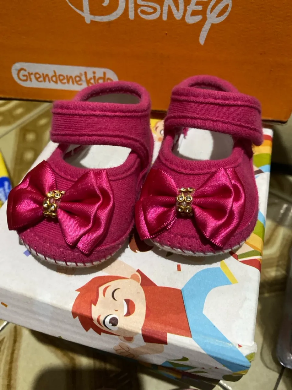 Sapatinho de bebê rosa com laço