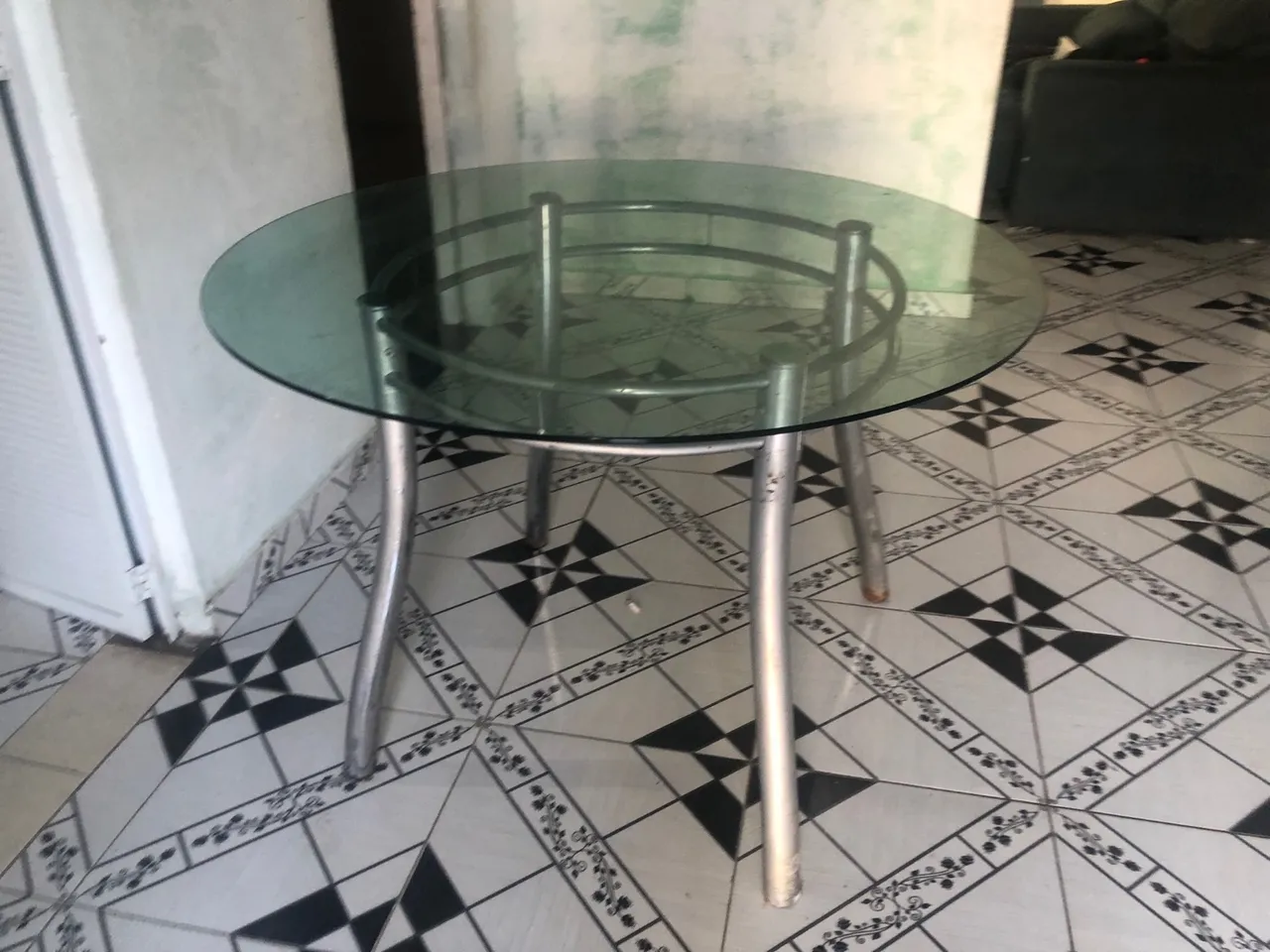 Mesa redonda de vidro com estrutura metálica