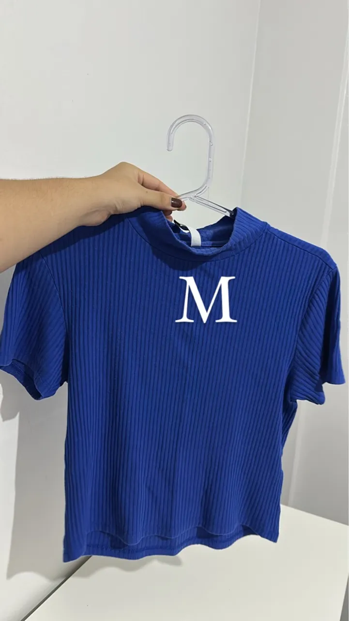Camiseta Azul com Gola Alta e Detalhe em 'M'