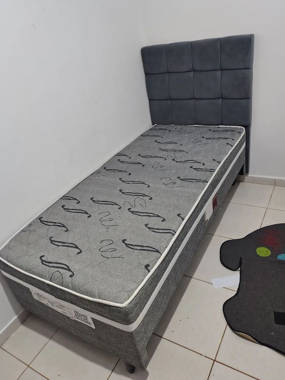 Cama solteiro com cama auxilia e cabeceira.