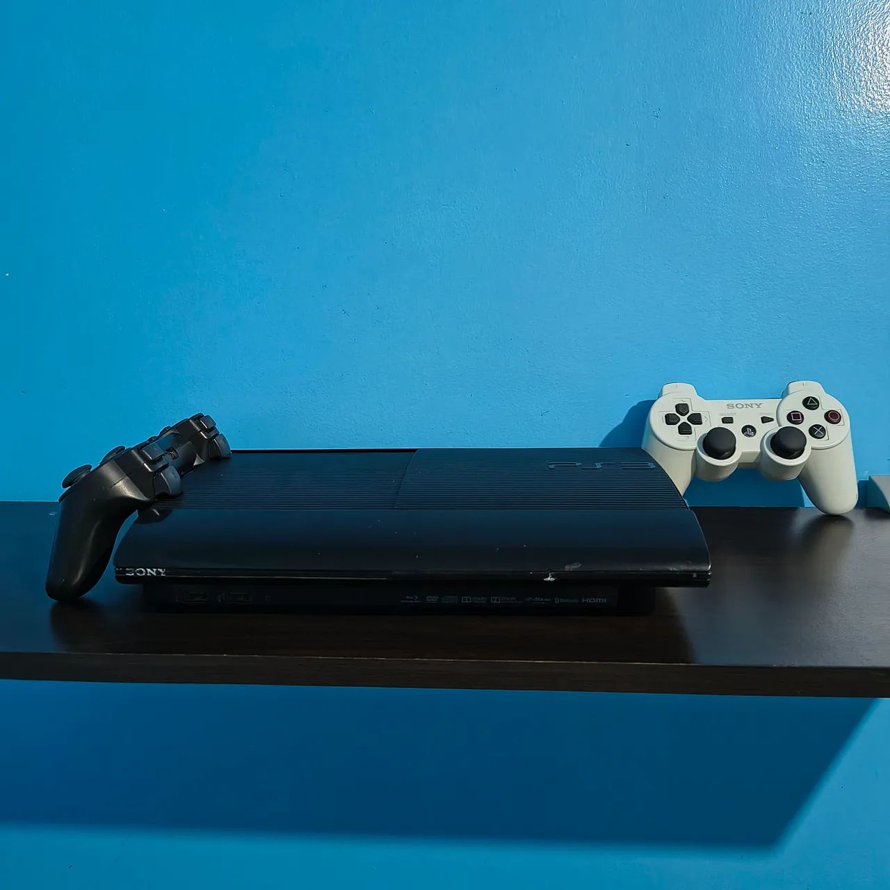 PS3 com dois controles e jogos
