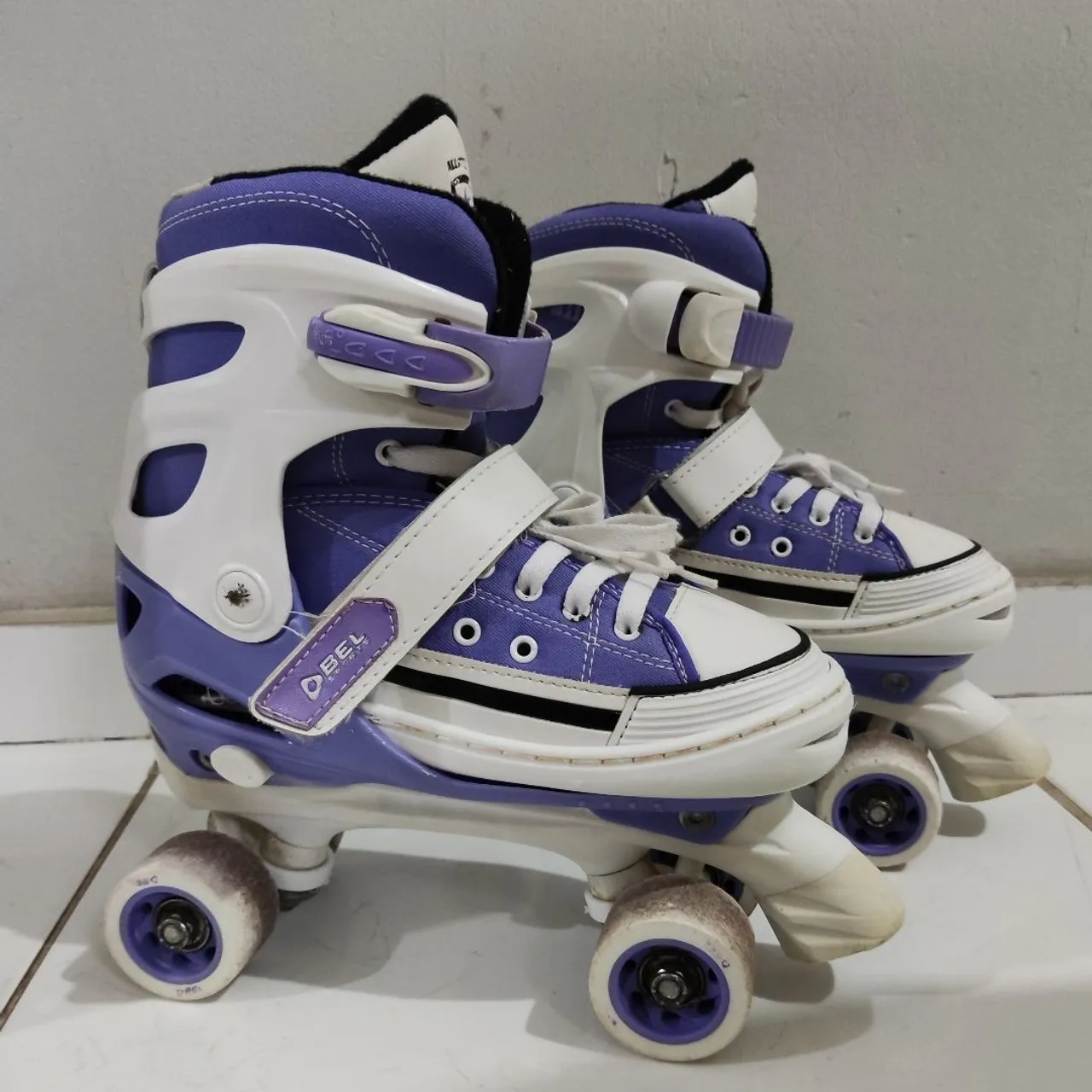 Patins All Style, nas cores roxo e branco, em bom estado de conservação.