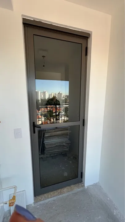 Porta de giro em vidro e alumínio na cor cinza