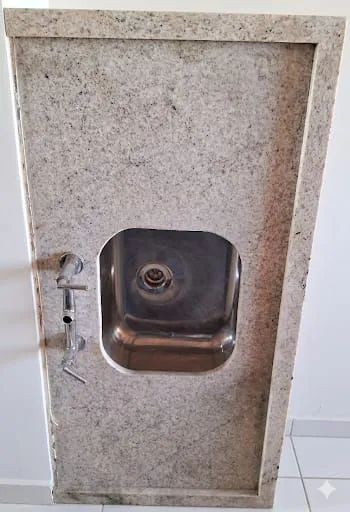 Granite sink with stainless steel basin and double-handle faucet.