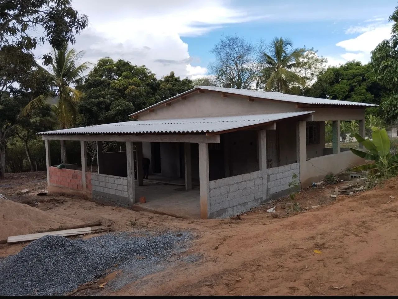 Terreno com casa em construção em área rural