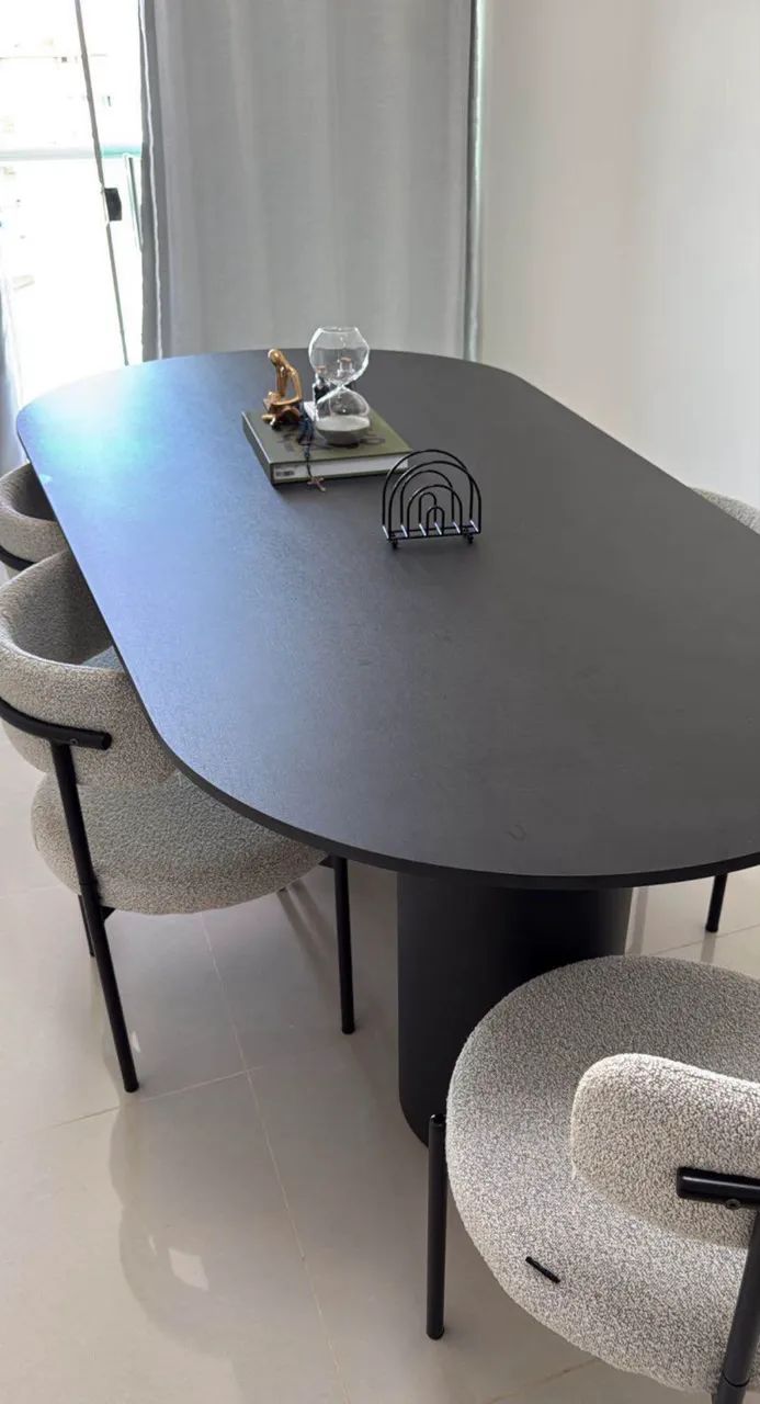 Mesa de jantar laminada com seis cadeiras e para até oito lugares.