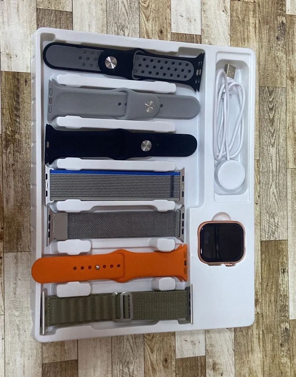 Smartwatch com diversas pulseiras e carregador