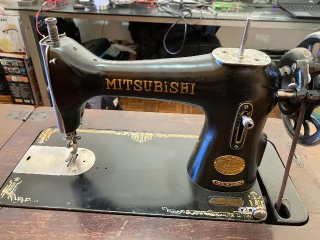 Máquina de costura Mitsubishi antiga com gabinete
