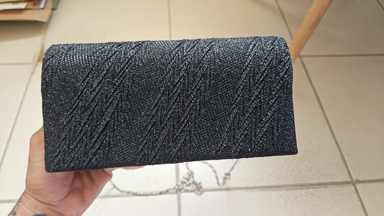 Bolsa de ombro preta com detalhes texturizados e alça de corrente