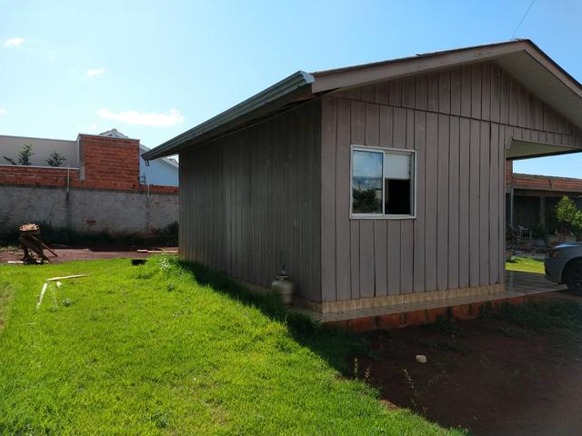 Terreno murado com casa de madeira