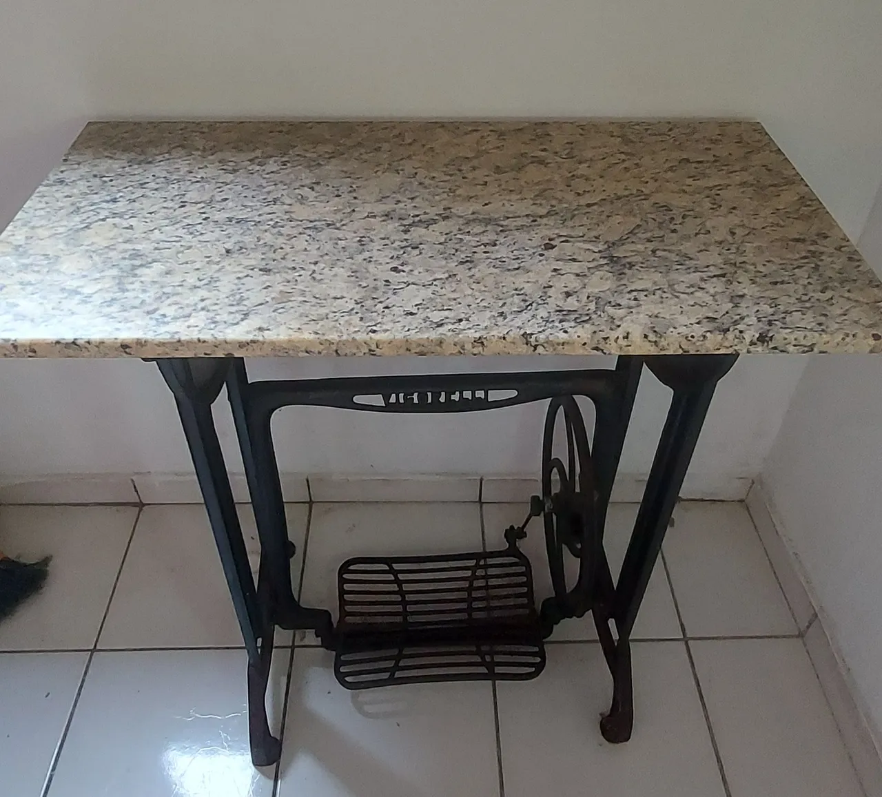 Mesa com base de máquina de costura antiga e tampo de granito