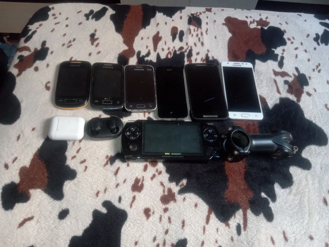 Celulares e fones de ouvido para retirada de peças ou conserto, um PMP e um braço de bike