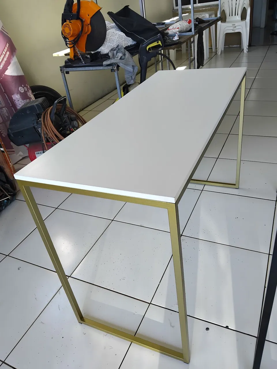 Mesa com estrutura dourada e tampo branco