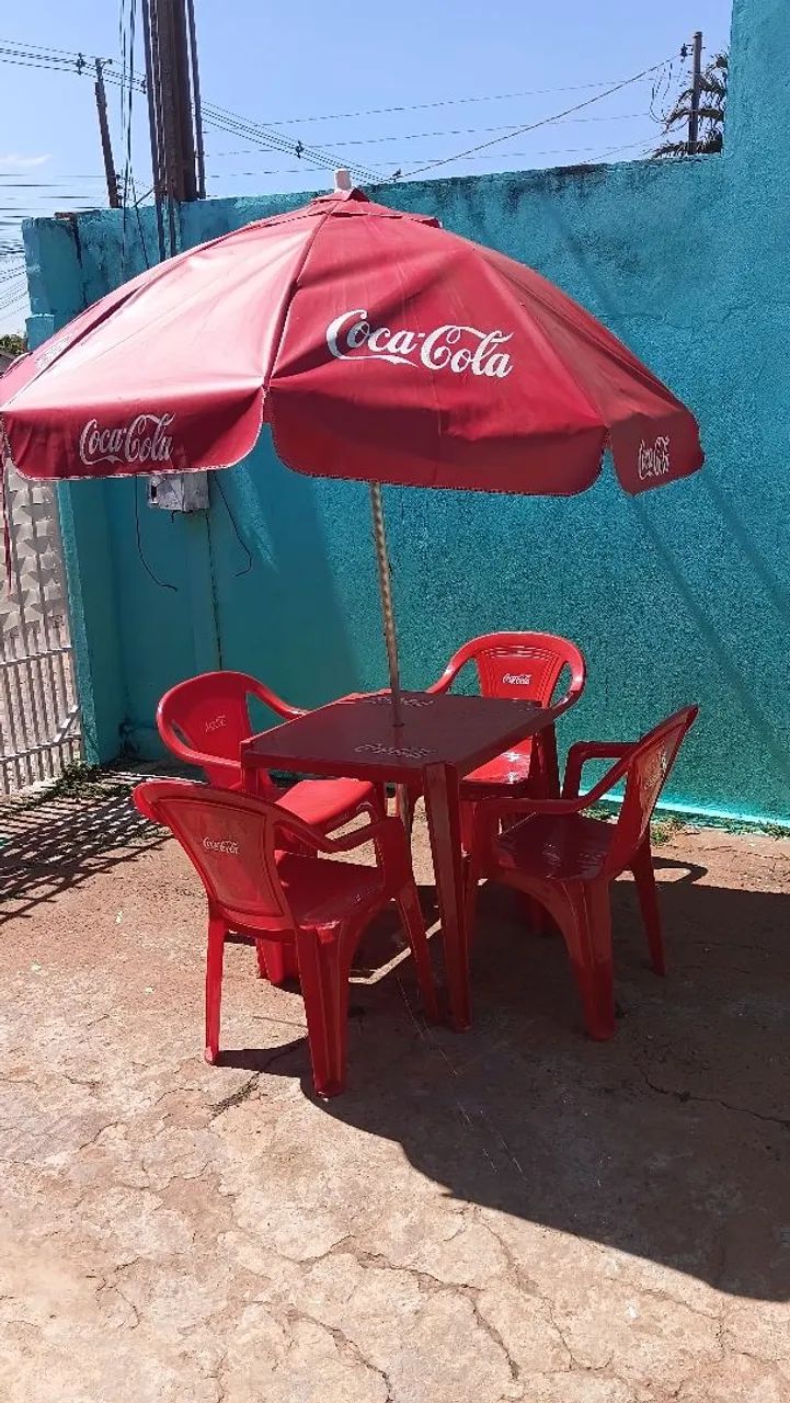 Mesa com 4 cadeiras e guarda sol.