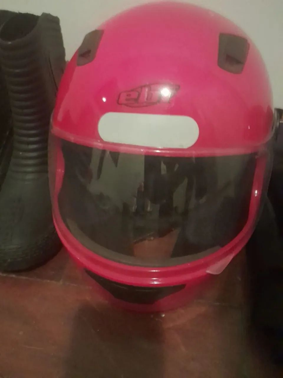 Capacetes, bota e roupa de chuva para moto.