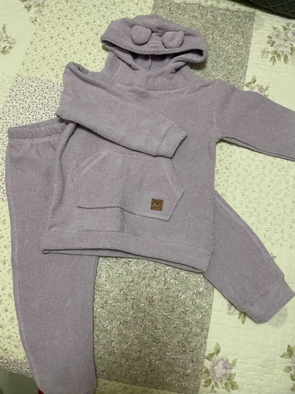 Este é um conjunto de moletom infantil verde com capuz e bolso canguru.