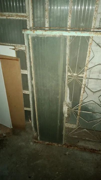 Janela de ferro com grade e vidro.