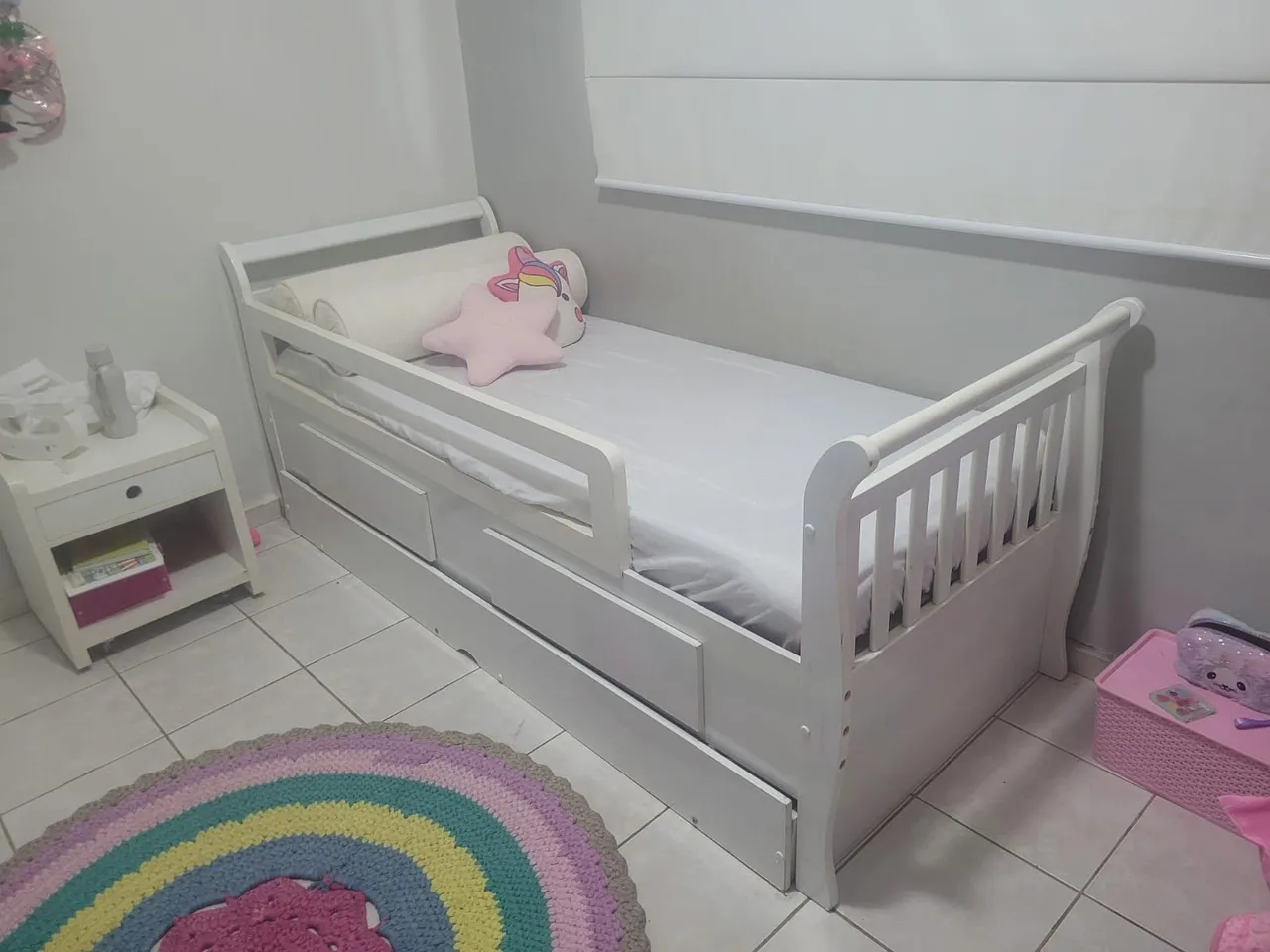 Cama infantil branca com grade de proteção e gavetas