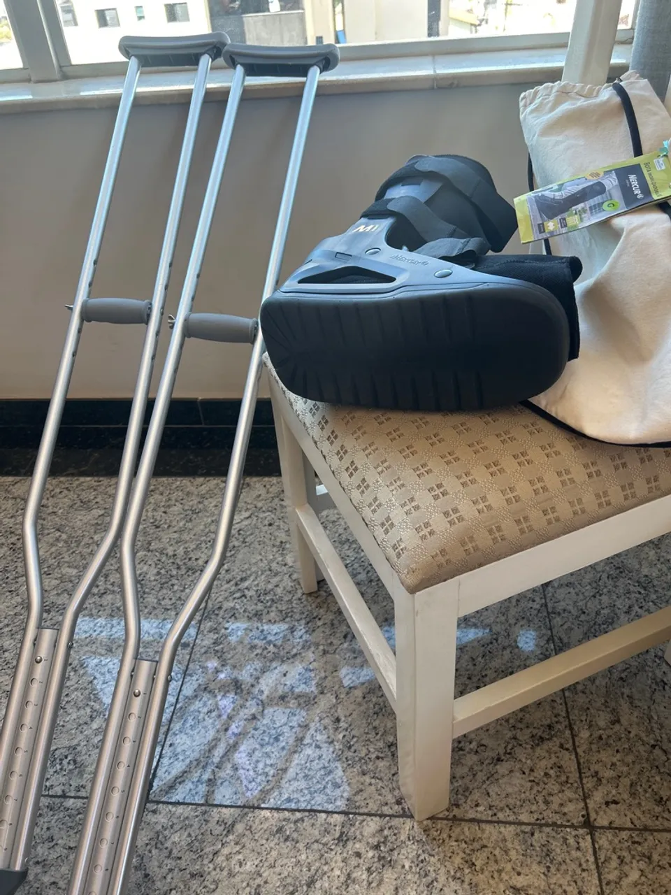 Bota ortopédica e muletas
