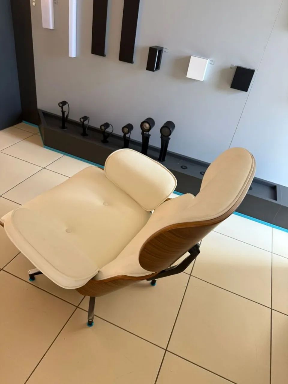 Poltrona modelo Charles Eames , madeira com acabamento em couro sintético claro.
