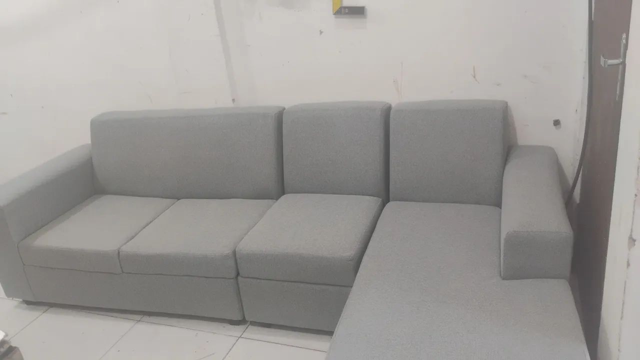 Sofá charse no tecido de linho acompanhado de pequenas almofadas como brinde .