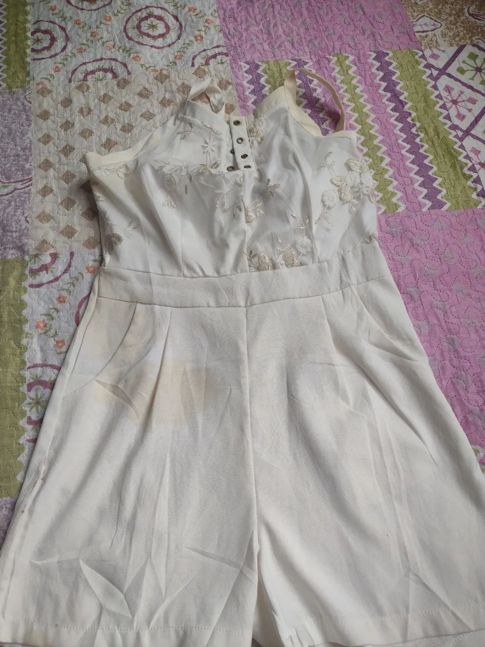 Macacão branco com detalhes em renda e defeito no fecho