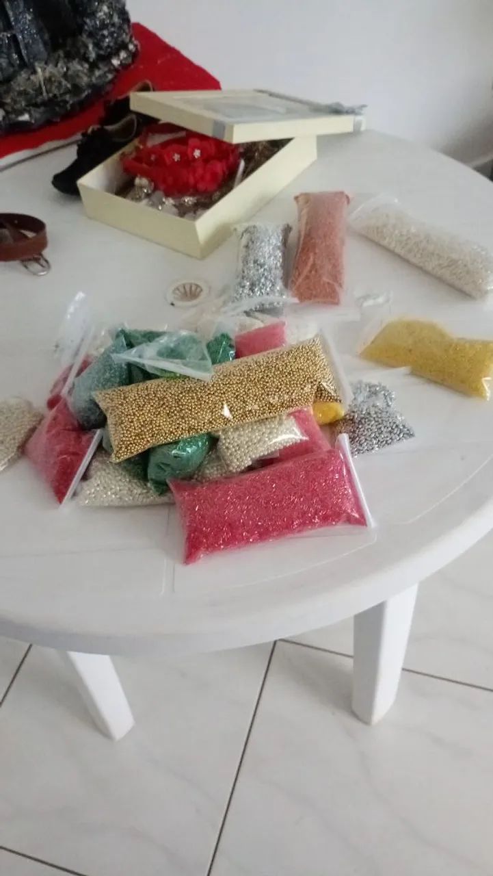 Pedrarias em liquidação de diferentes cores, vermelho, amarelo, verde e pérolas.