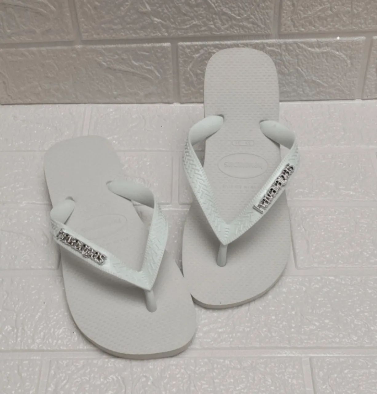 Chinelos Havaianas Branca com plaquinha logomarca prata 