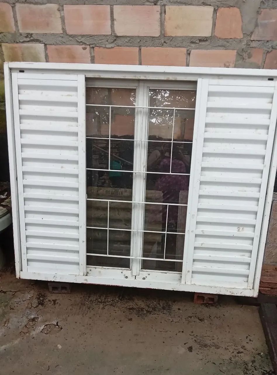 Janela de aço com grade e veneziana