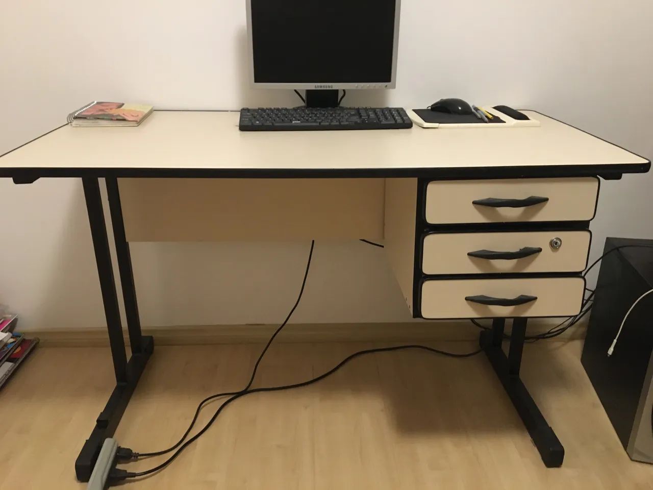 Mesa escritório com três gavetas e chave.