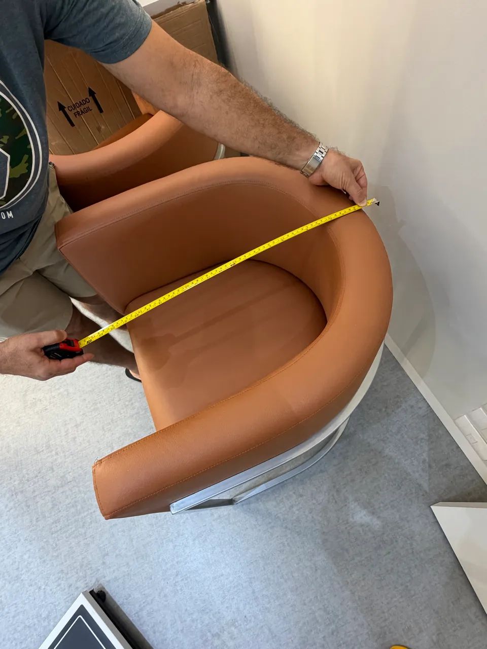 Poltronas estrutura metal prateado e assento em courino marrom.