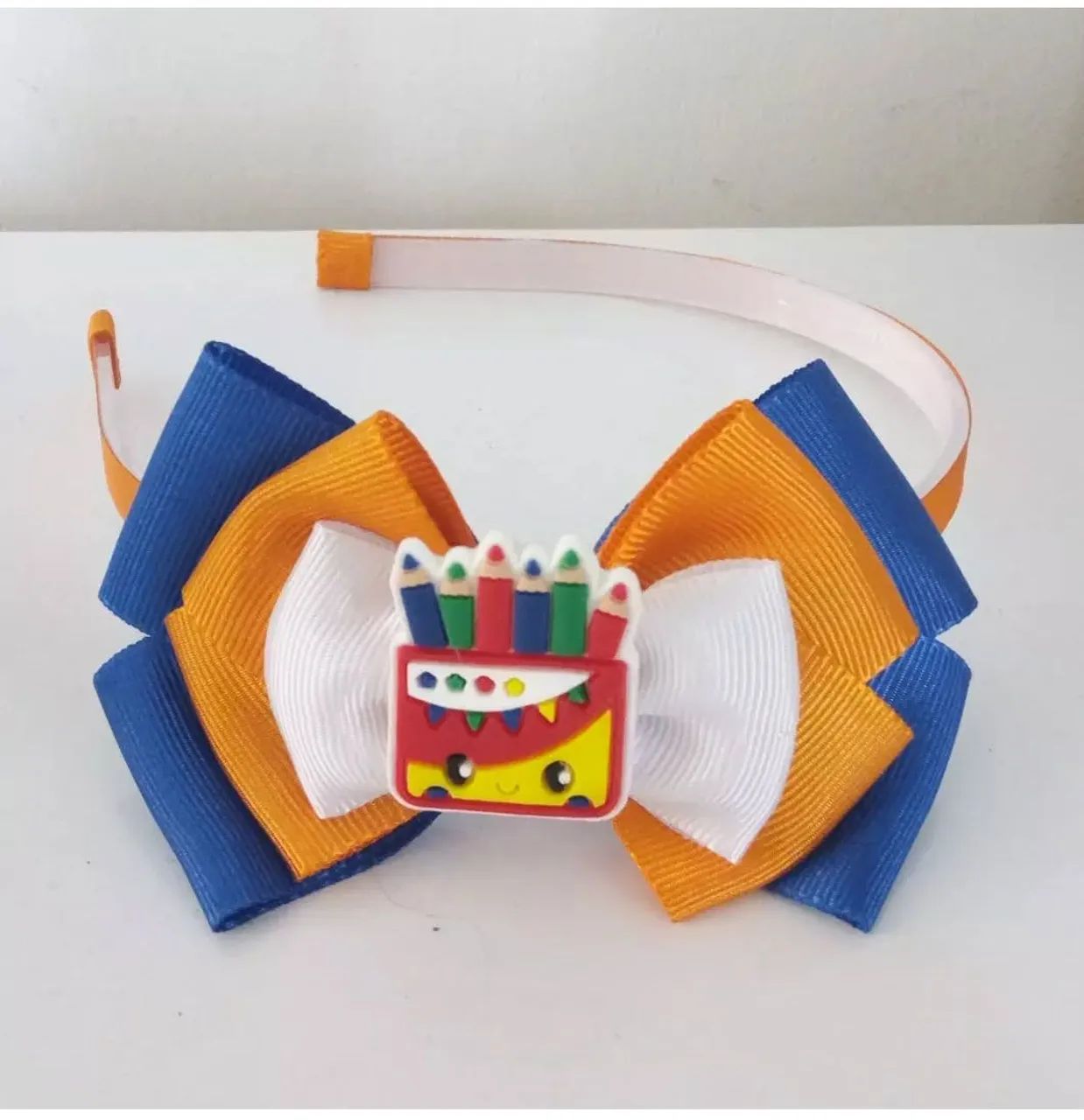 Tiara Arco com Laço e Aplique de Lápis de Cor