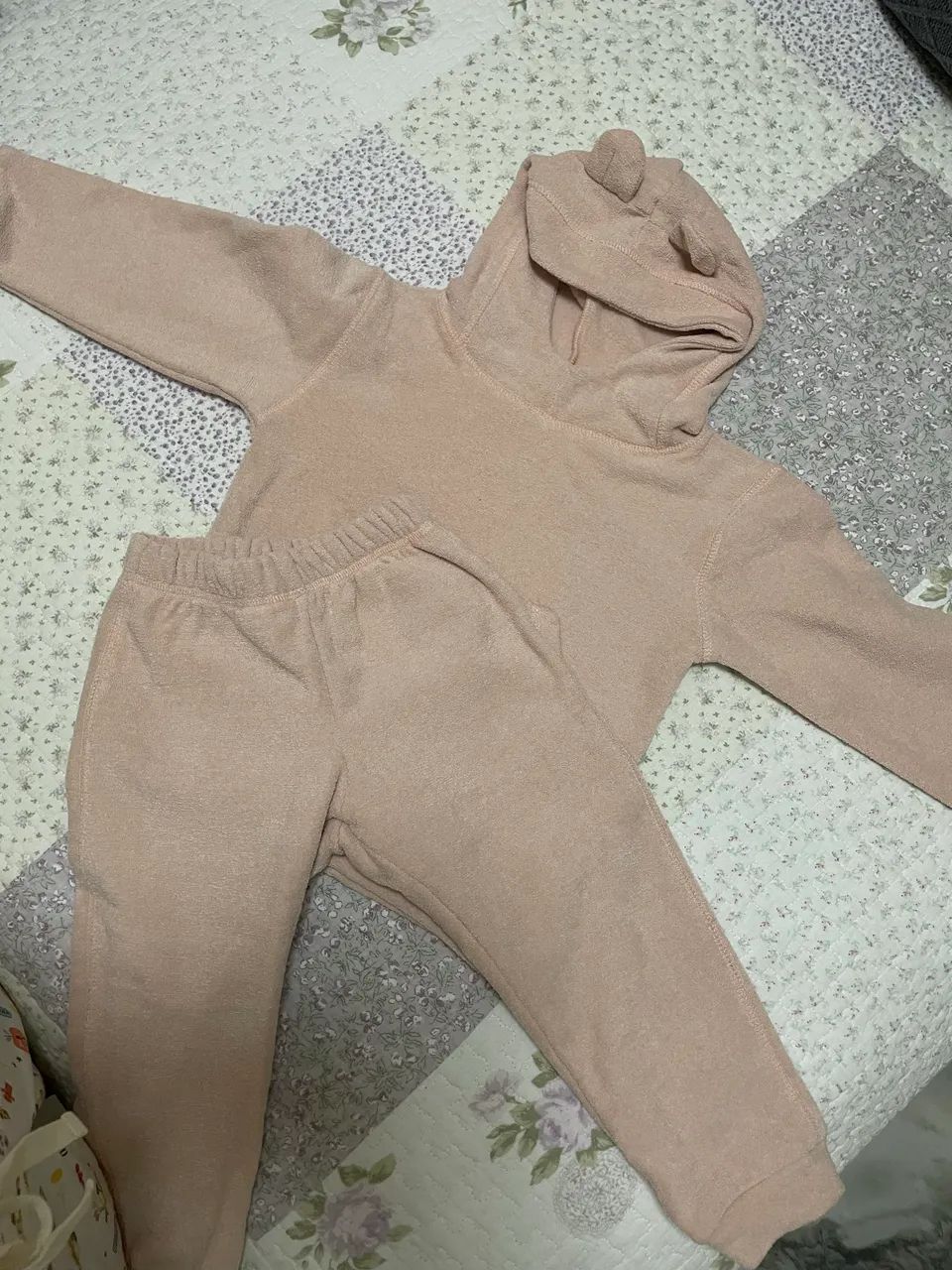Este é um conjunto de moletom infantil verde com capuz e bolso canguru.