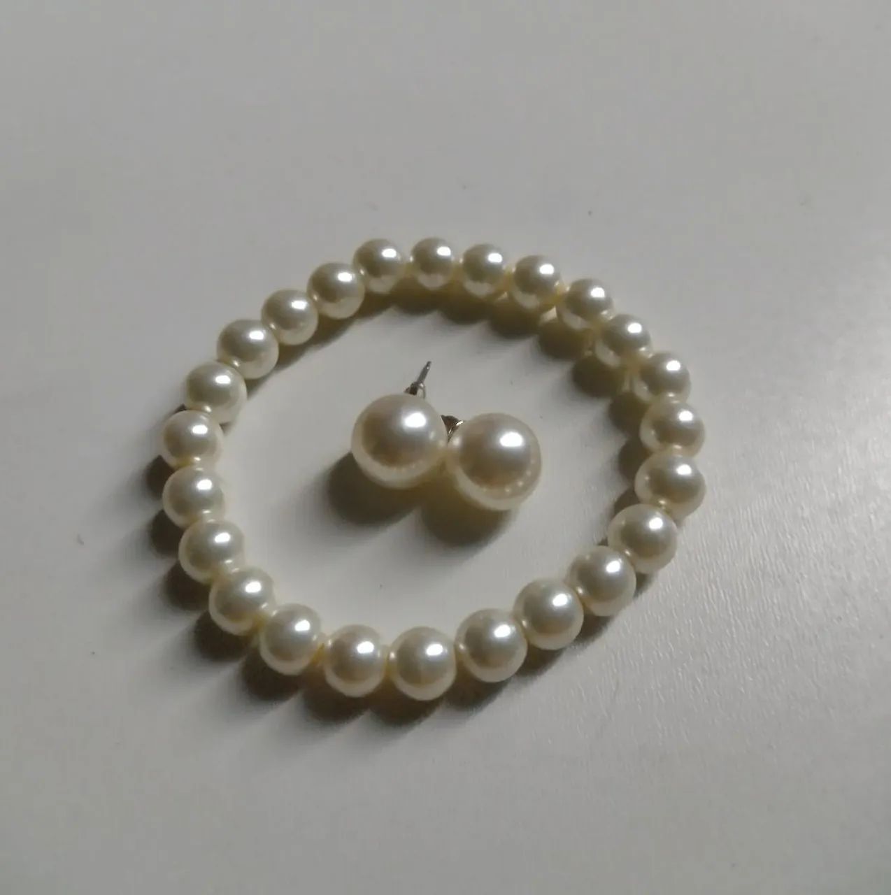 Conjunto de brincos e pulseira de pérola.