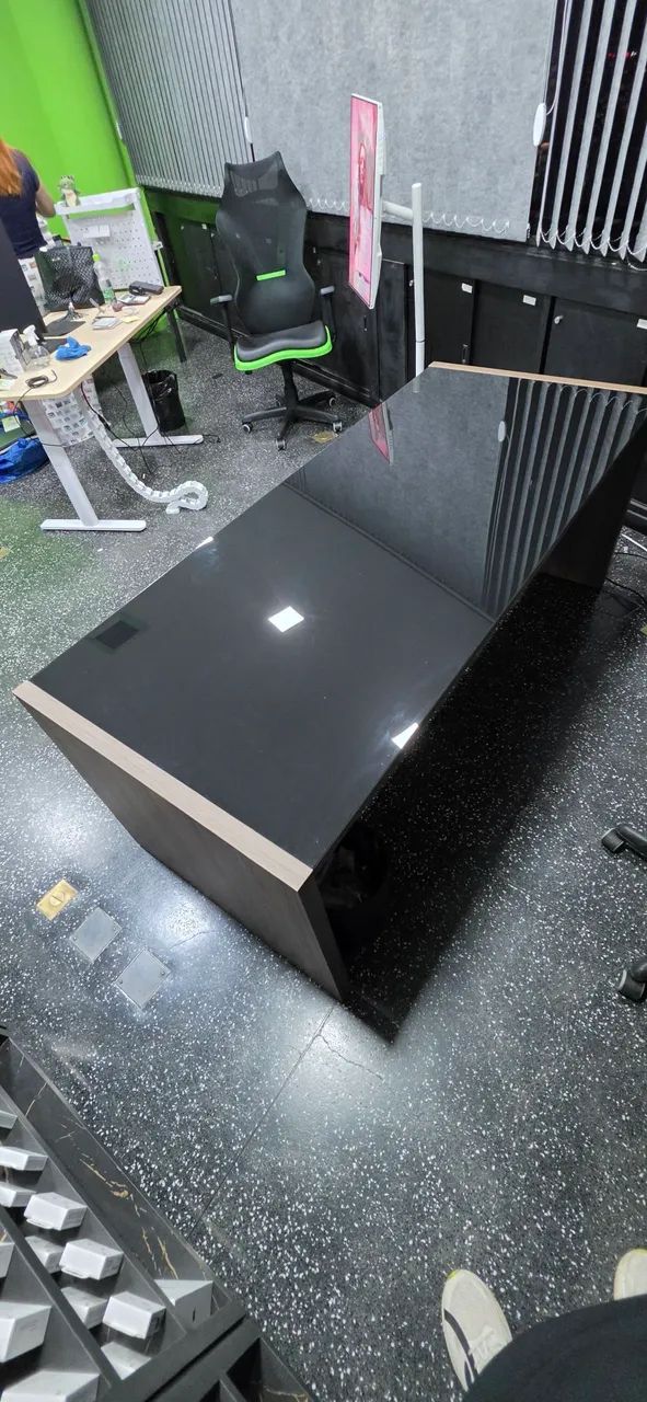 Mesa de Escritório com tampo de vidro escuro.