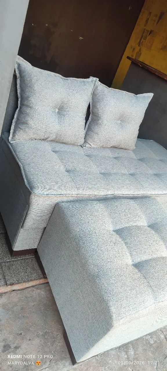 Sofá de 3 lugares acompanhado por um puff