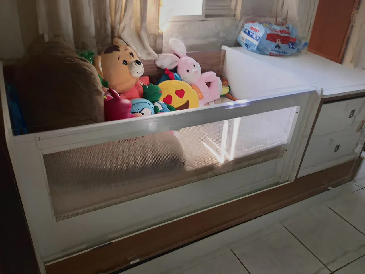 Berço de bebê com grade de proteção